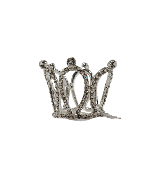 Silver crown-shaped object on a reflective surface with a gray background