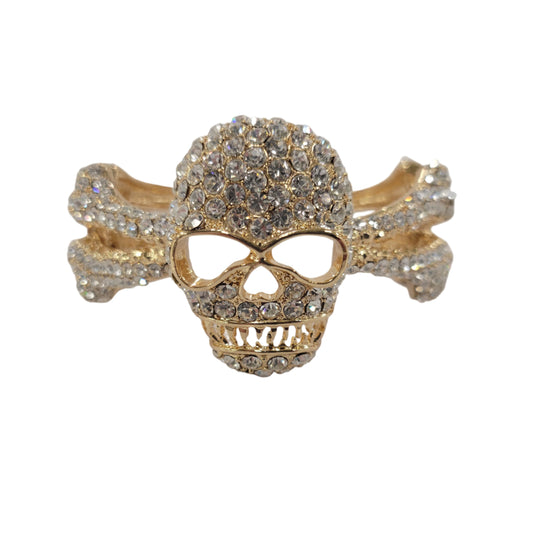 Gold skull ring with gemstones on a light gray background